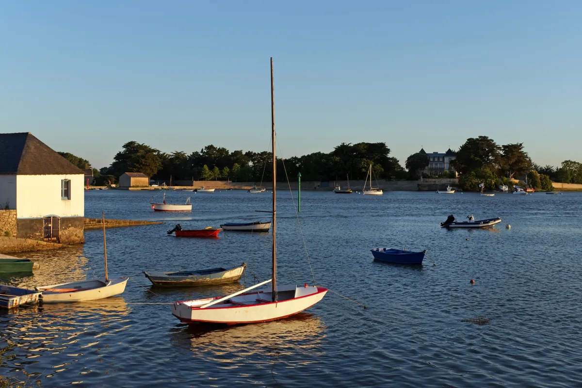 Chenal Saint-Léonard dans le Morbihan avec petits bateaux au coucher du soleil

